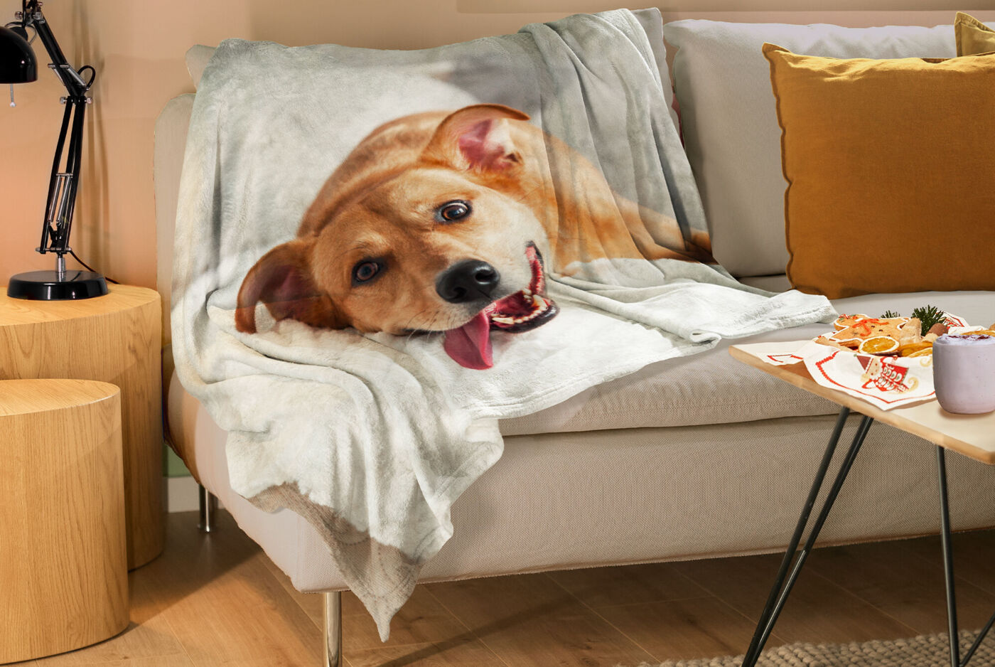 Manta personalizada con foto con color de perro, colocada sobre un sofá en salón.