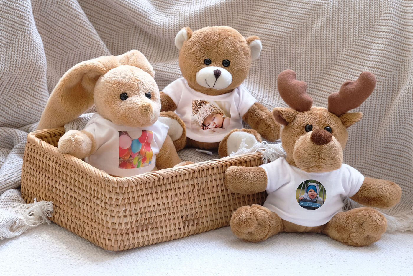 Tres peluches en camisetas con fotos sentados en una cestita